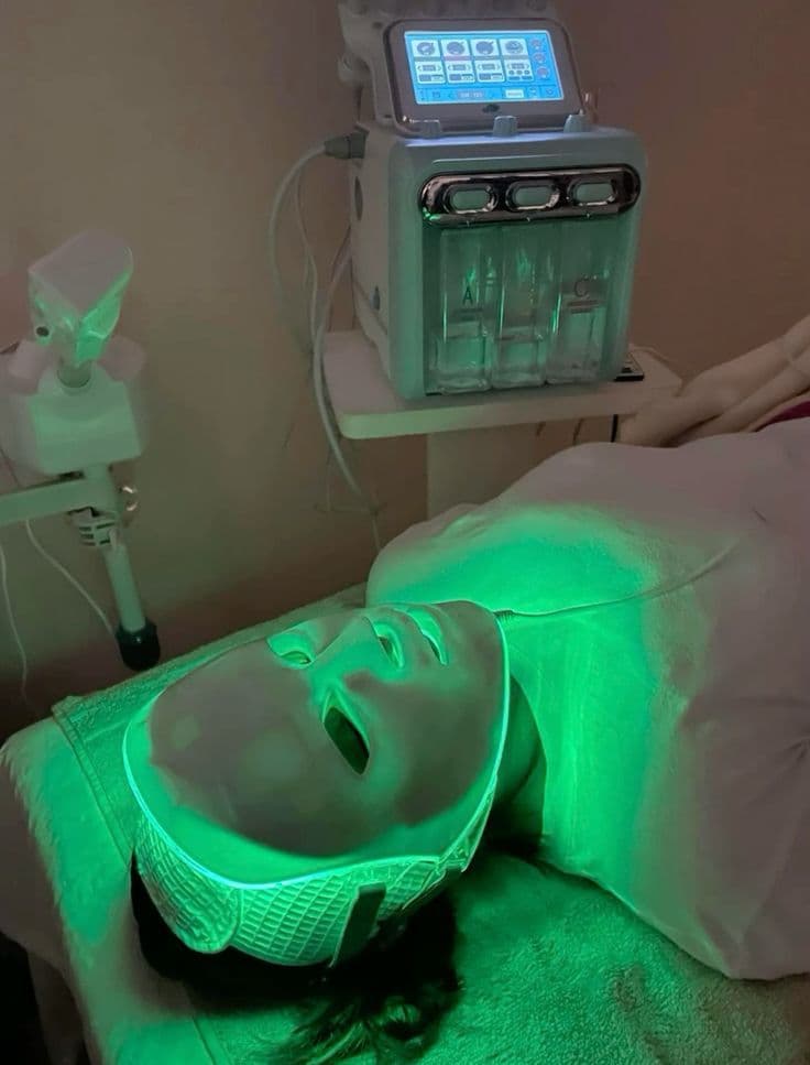 Beberta Aesthe — LED yüz bakım maskesi seansı; arkada HydraFacial benzeri 3 fazlı temizlik cihazı
